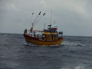 Fishing boat coming really close, not the fisherman right up on the bow.